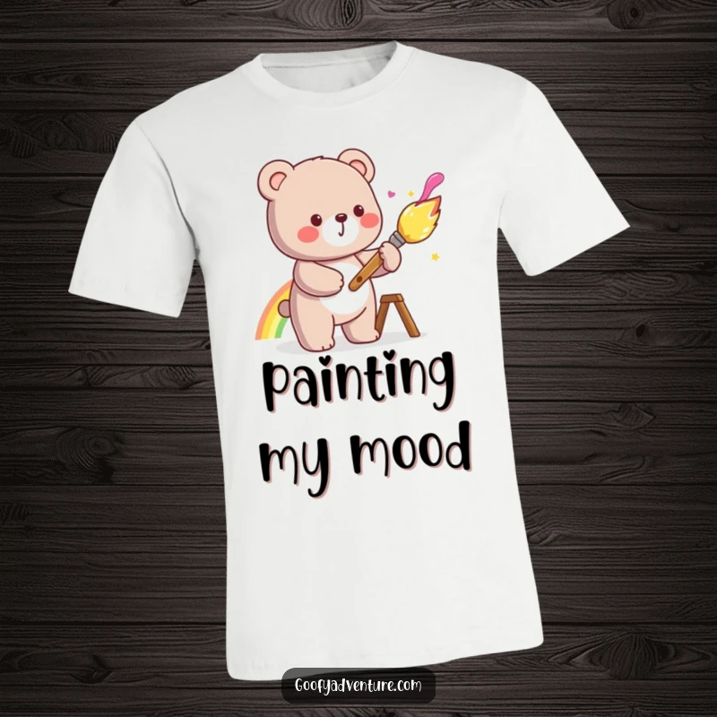 Funny kawaii bear painting a beautiful rainbow with a large, cheerful paintbrush, printed on a comfortable t-shirt.